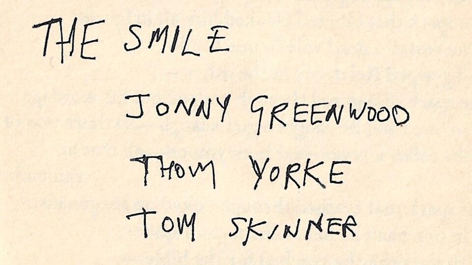 Texte écrit à la main où on peut lire The Smile, Jonny Greenwood, Thom Yorke et Tom Skinner