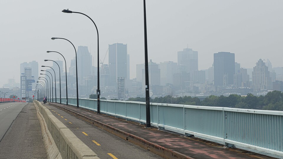 Montréal se dessine au loin dans un épais brouillard.