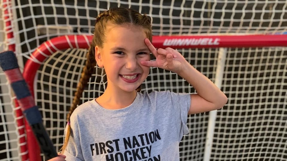 Une fillette qui porte un T-shirt Smudge the Blades sur un terrain de hockey.