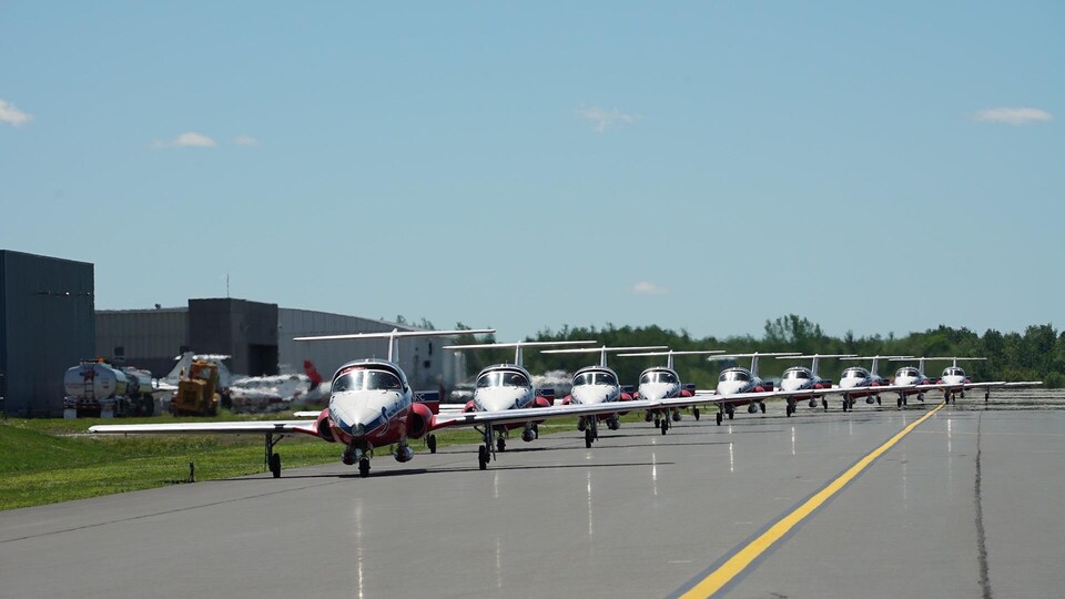 Plusieurs avions des Snowbirds sur une piste d'atterrissage.