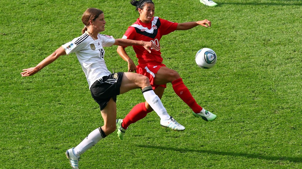 Deux joueuses de soccer luttent pour le ballon pendant un match.