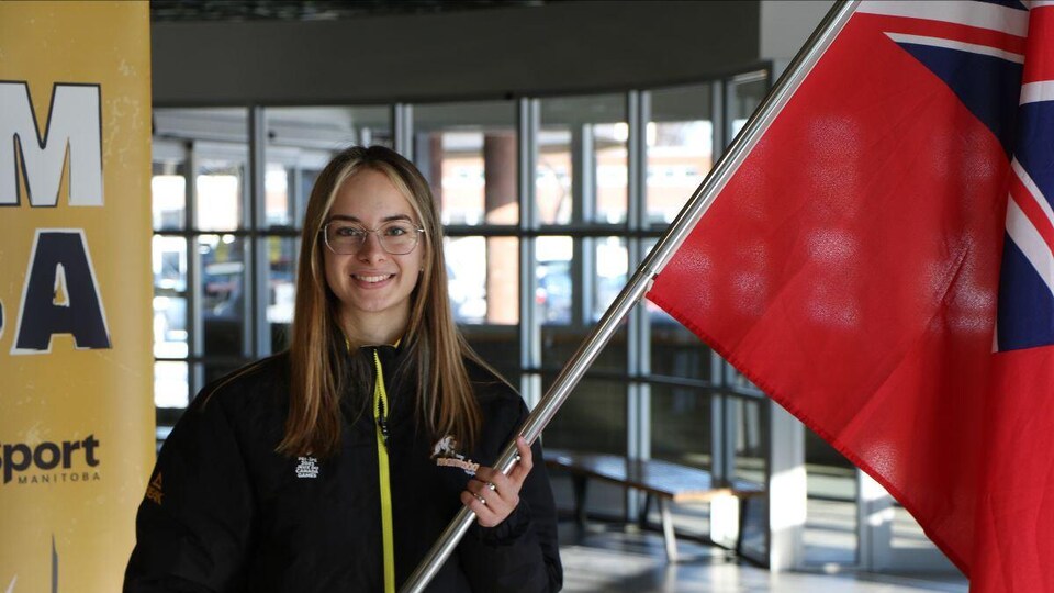 La patineuse de vitesse Sofia Bieber porte le drapeau du Manitoba.