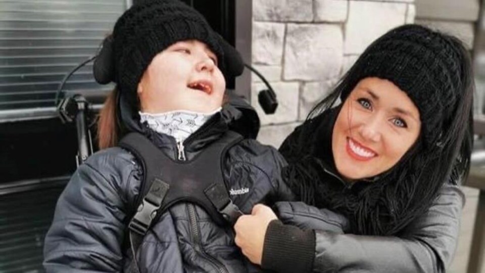 Mélanie Cossette, toute souriante, pose avec sa fille handicapée, Sofianne.
