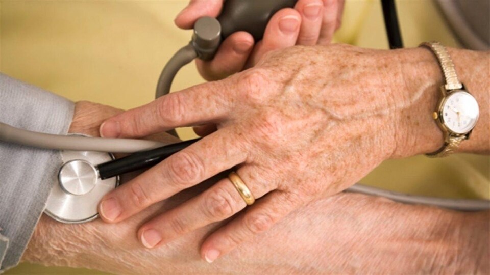 La main du médecin avec son appareil et le bras de la patiente.