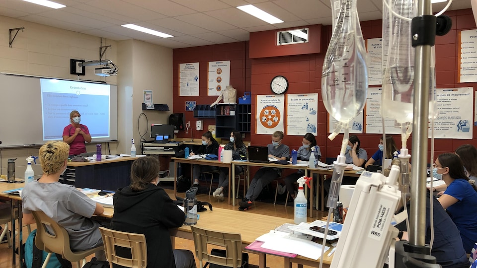 Des étudiants en soins infirmiers assistent à un cours derrière un soluté.