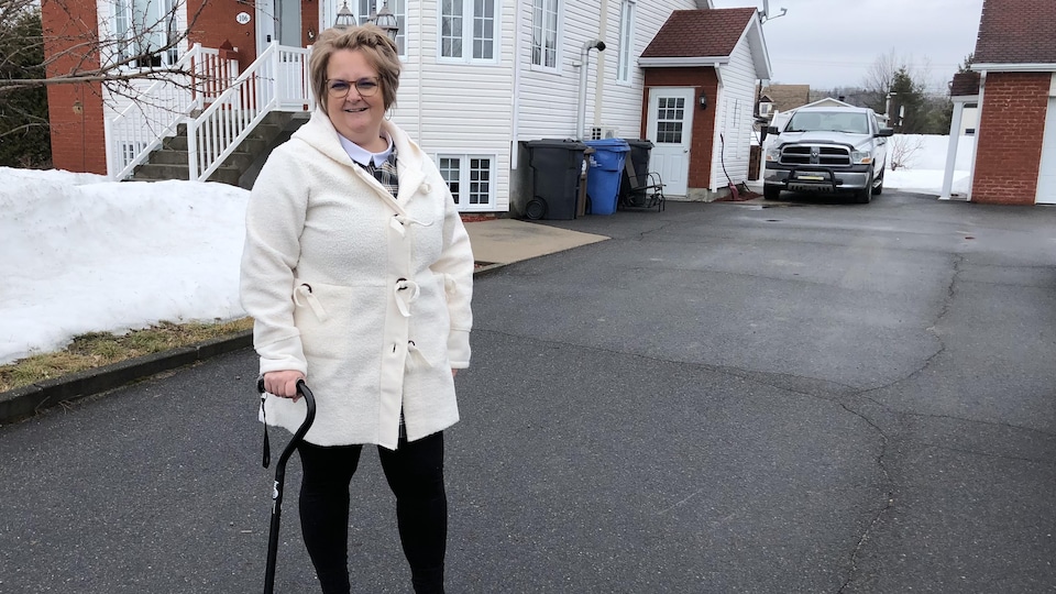 A woman standing in front of her house. 