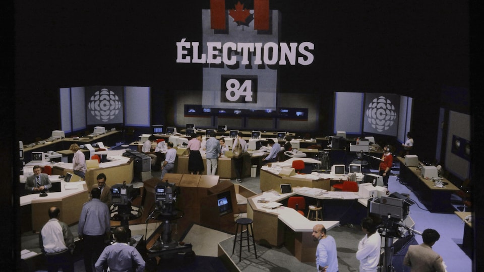 Plateau de la soirée électorale fédérale de 1984 avec plusieurs bureaux équipés d'ordinateurs.
