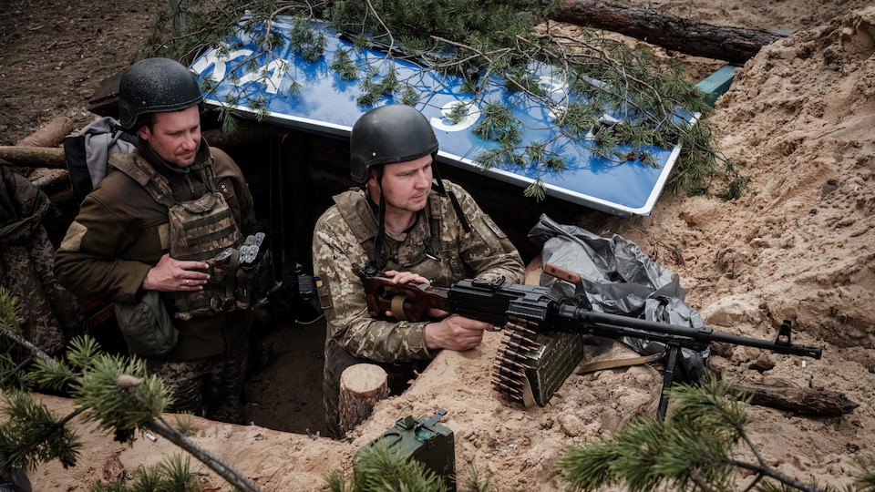 Deux soldats ukrainiens en position avec leurs armes. 