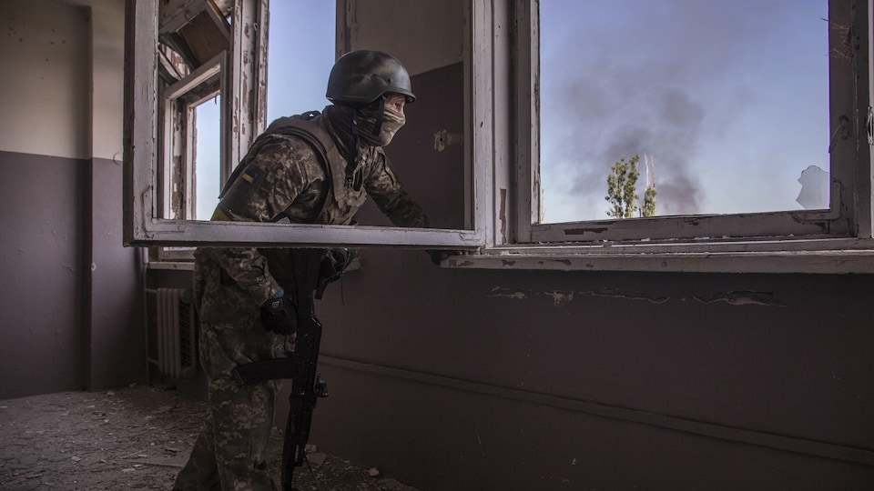 Un soldat prend position près d'une fenêtre.