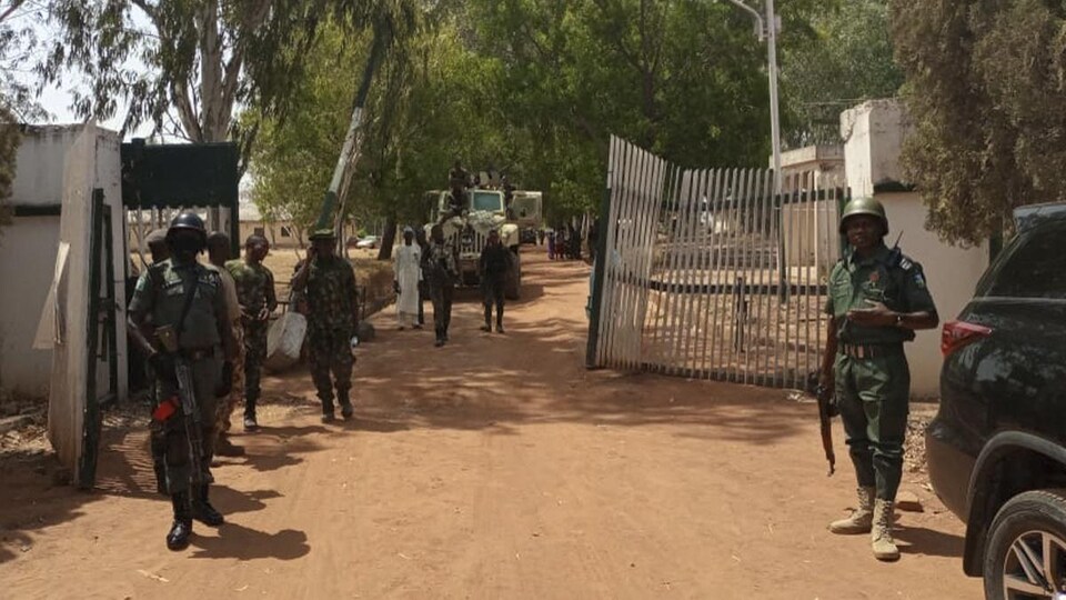 Des soldats devant une barrière.