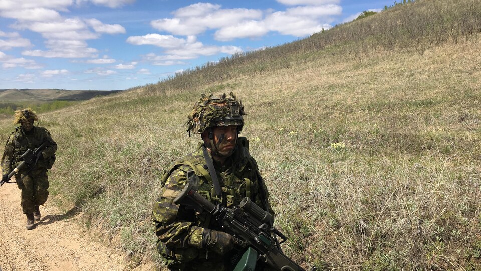 Des soldats marchent sur un chemin.