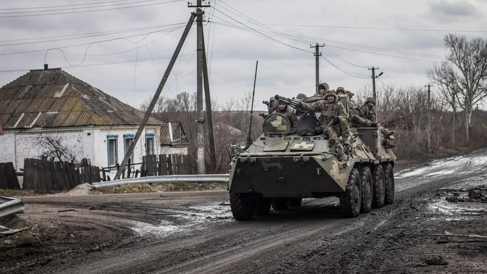 Des militaires ukrainiens sur un véhicule blindé de transport de troupes.