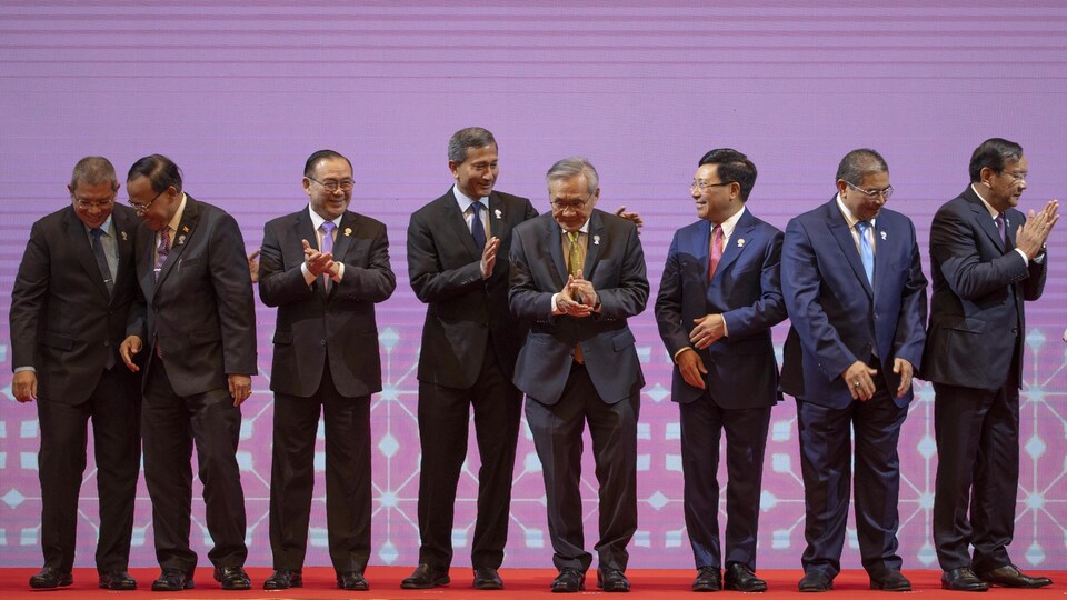 Les ministre des Affaires étrangères des pays de l'Asie du Sud-Est applaudissent ensemble sur une scène.
