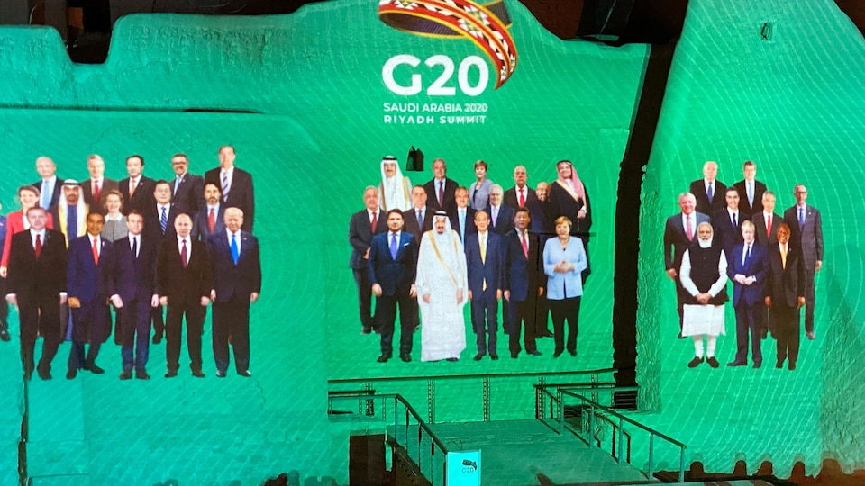 Une photo de groupe virtuelle des dirigeants du G20 projetée sur un écran.