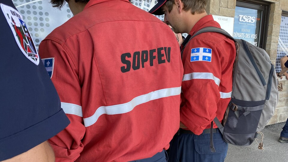 Quelques pompiers de dos jasent ensemble avant le départ.