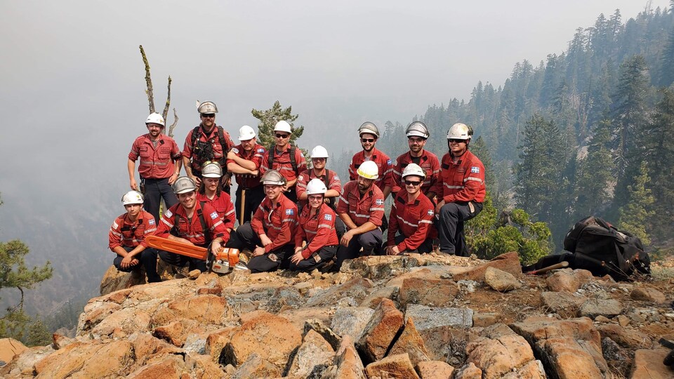 Des pompiers forestiers réunis sur un cap de roche.