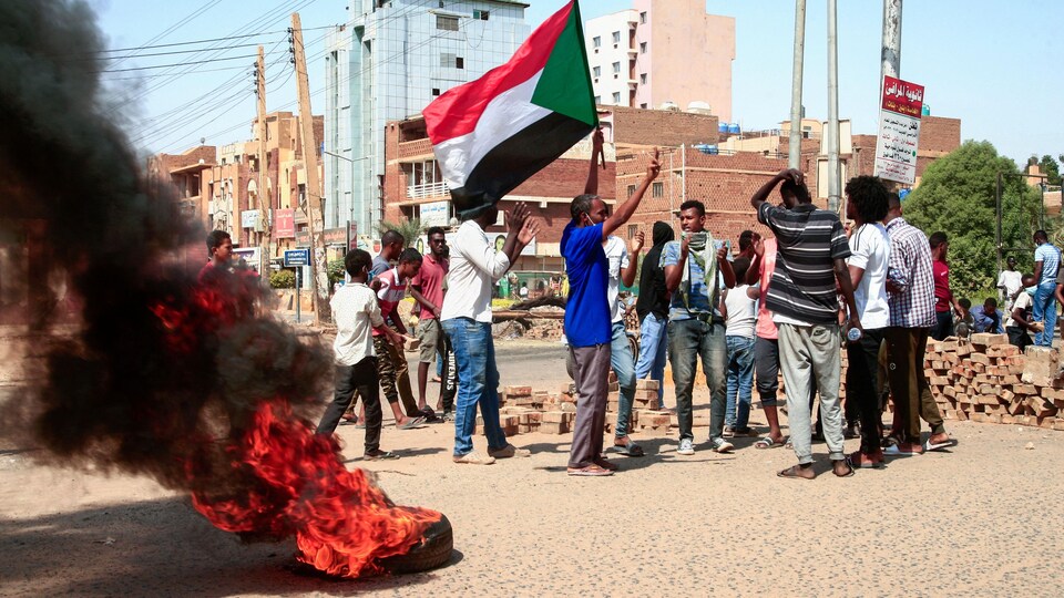 Des manifestants brandissent un drapeau dans la rue.