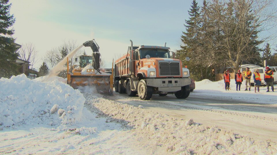 Une souffleuse et un camion ramassent de la neige à Gatineau.