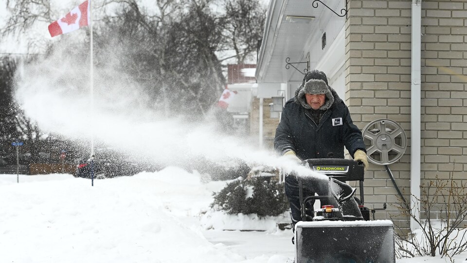 Stan Perkovic utilise une souffleuse pour déneiger après une tempête hivernale.