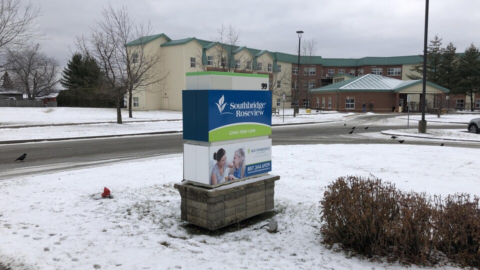 L'affiche extérieure du centre de soins de longue durée est devant l'établissement sur un terrain gazonneux couvert de neige.