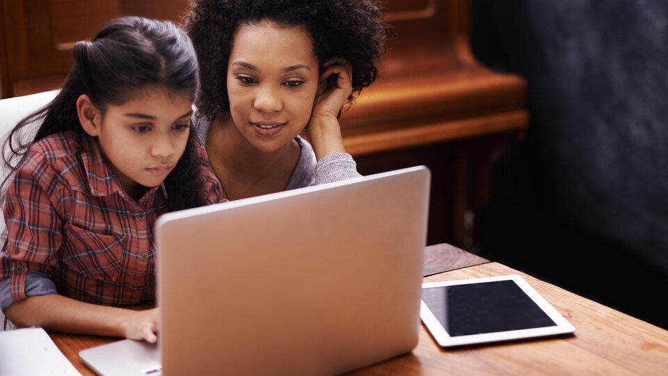 Une mère fait des devoirs avec sa fille.