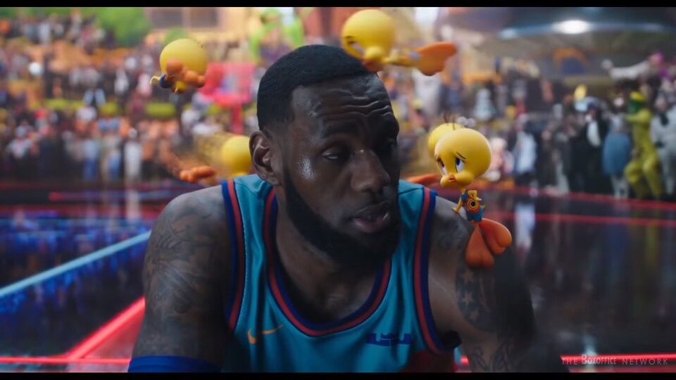 Un joueur de basket est assis alors que des petits oiseaux jaunes en dessins animés lui tourbillonnent autour de la tête.