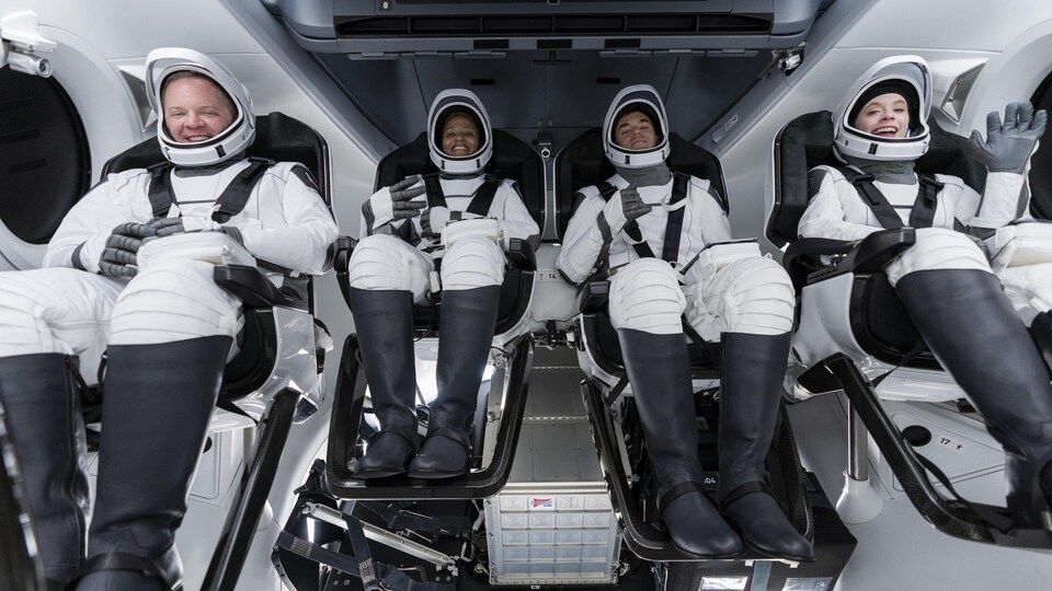 Quatre personnes en combinaison spatiale.