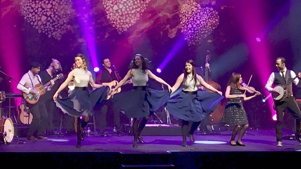 Des danseuses et musiciens sur une scène.