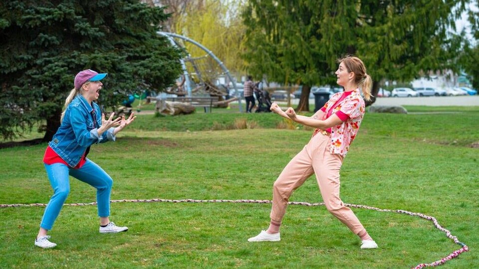 Deux danseuses se font face dans un parc entourées d'un cercle.
