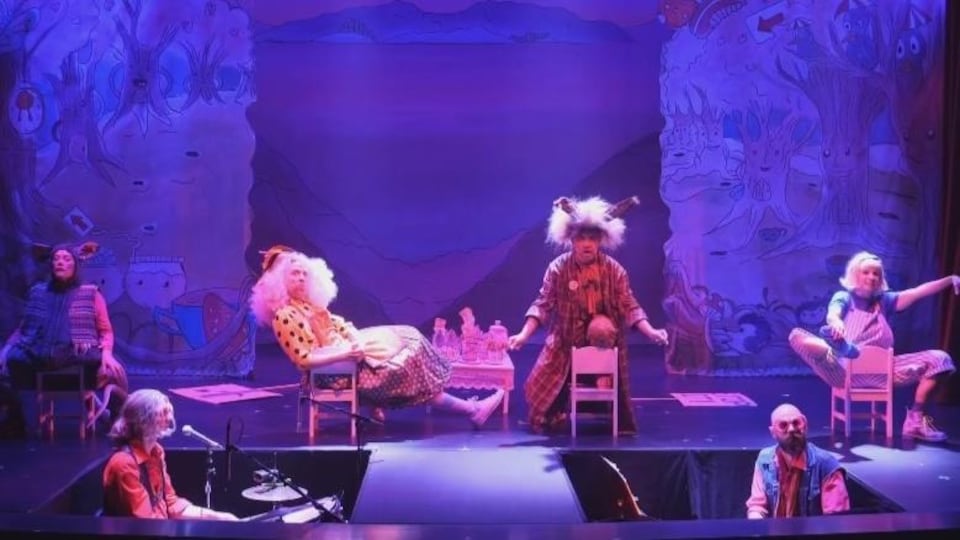 Quatre acteurs et deux musiciens sur une scène de théâtre.