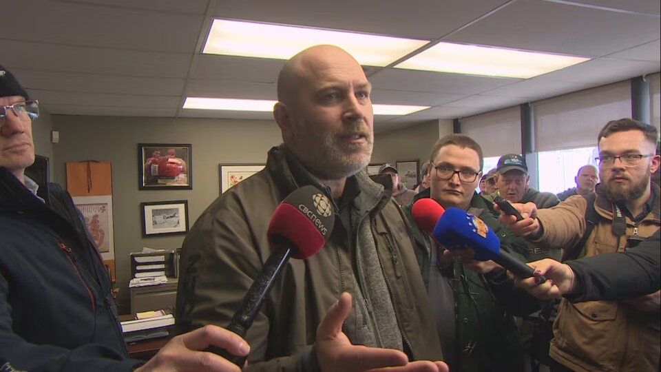 Jason Spingle parle aux manifestants rassemblés dans une salle.
