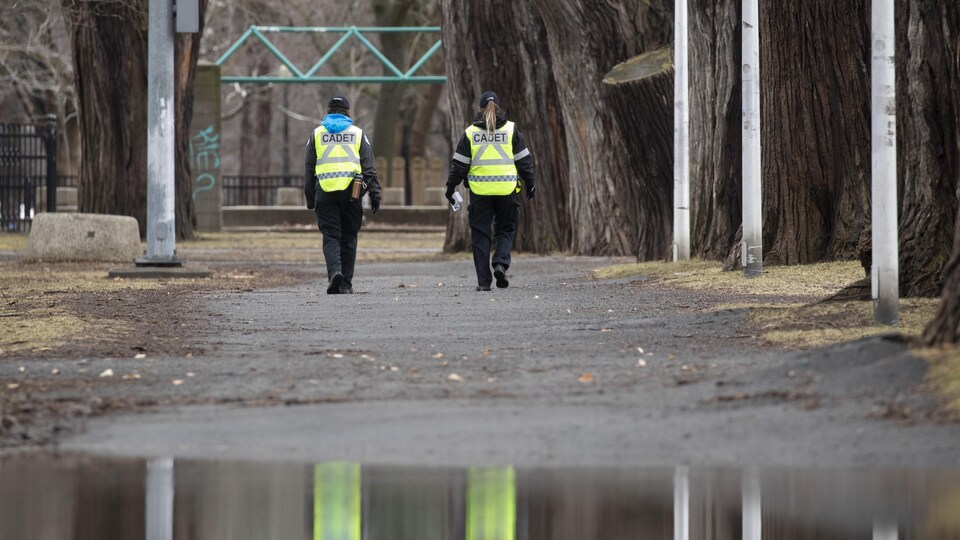 Deux cadets du SPVM marchent côte à côte dans un parc.