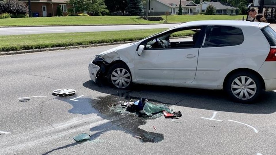 Une voiture dont l'avant est amochée est au milieu de la rotue.