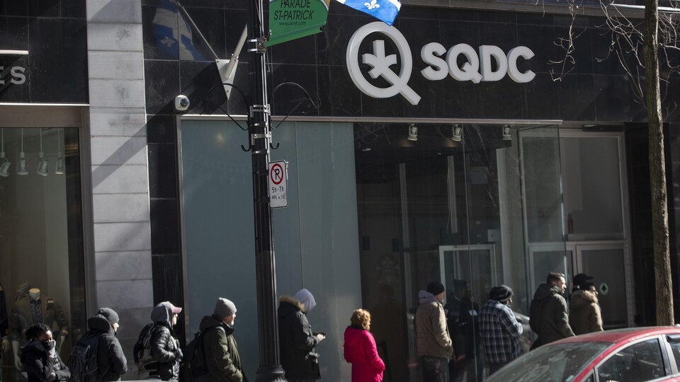 Des gens en file devant une succursale de la SQDC à Montréal.