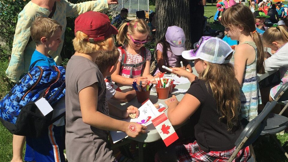 Des enfants dessinent à l'extérieur.