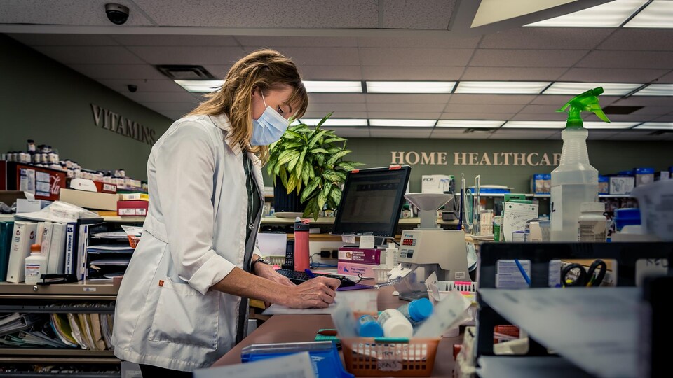 Stacy Jardine prenant des notes à son comptoir de pharmacie.
