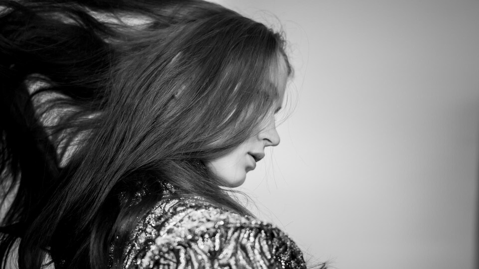 Gabrielle Lapointe lève ses cheveux. Elle est de profil. 