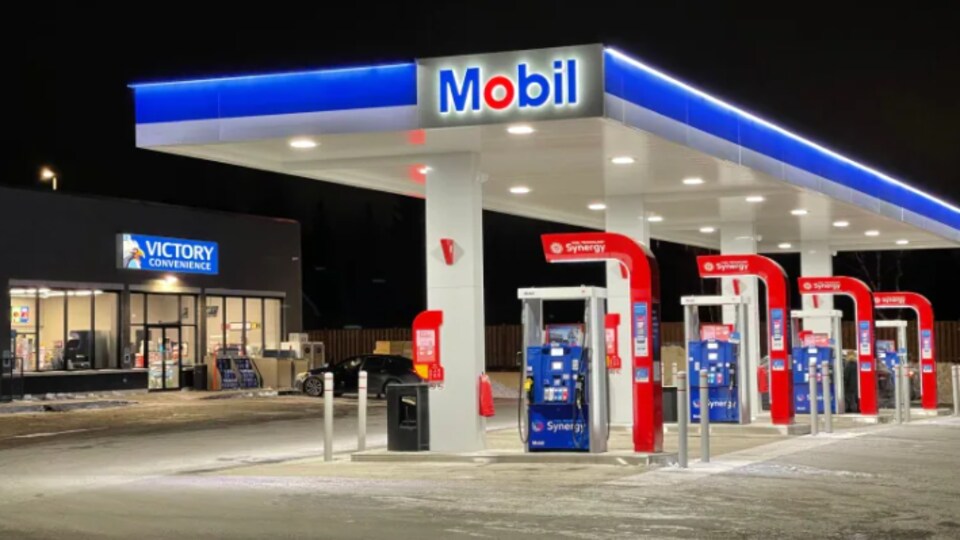 Une station-service et un dépanneur en pleine nuit.