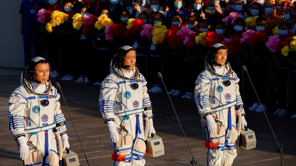 The three Chinese astronauts are surrounded by admirers. 