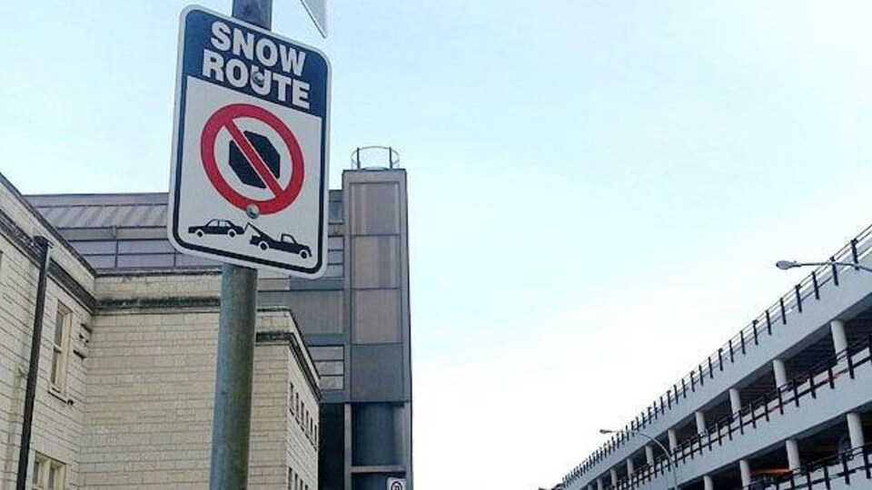 Une affiche d'interdiction de stationnement dans une route désignée comme rue de neige.