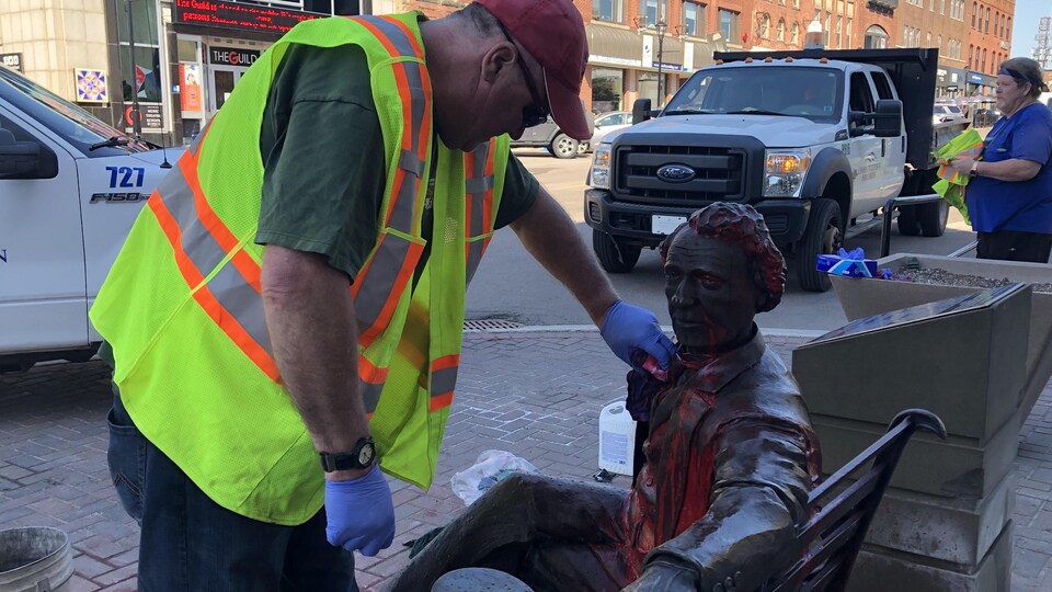Un travailleur nettoie la statue.