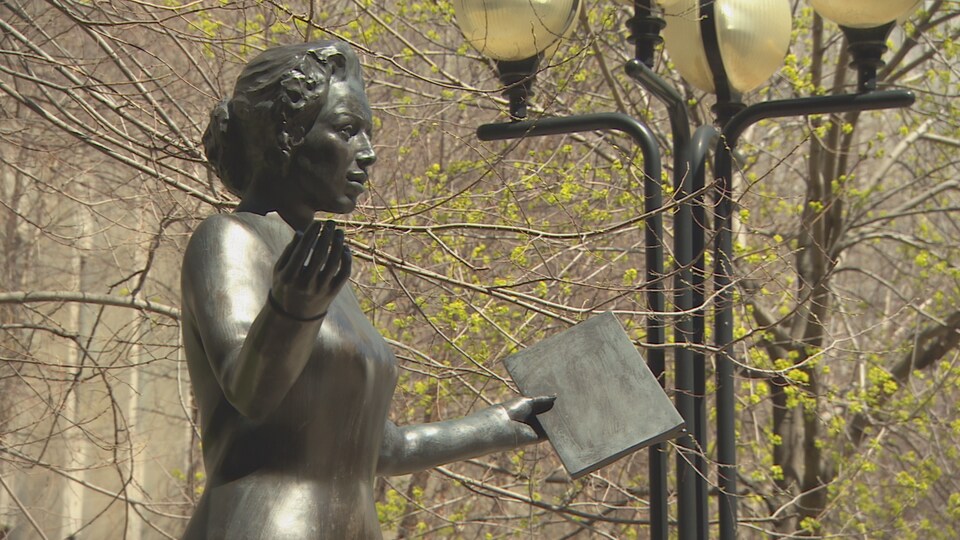 Photo de la statue d'une femme avec un livre.