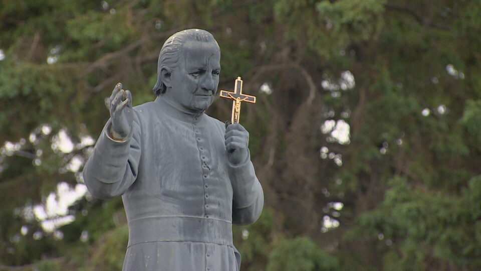 Il tient un crucifix dans sa main gauche.