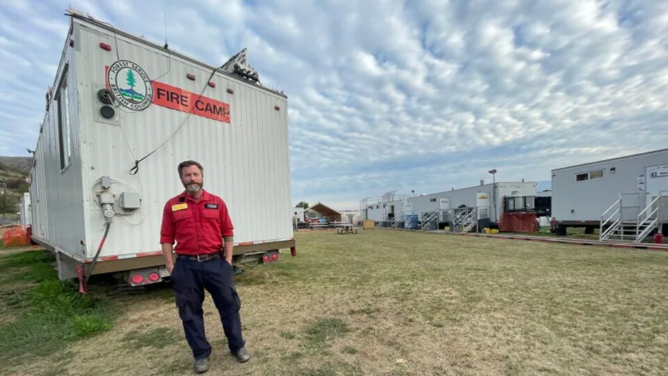Un homme au milieu de bâtiments préfabriqués.