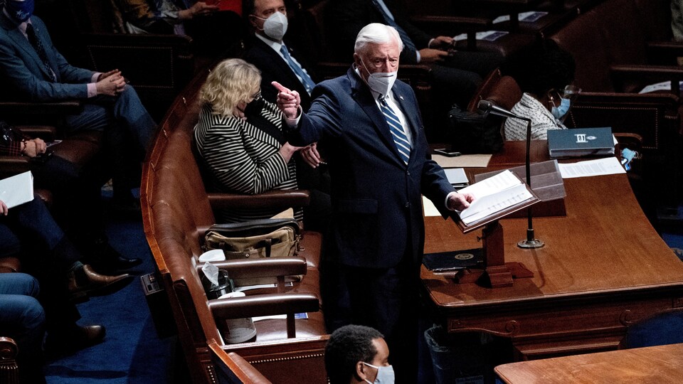 Steny Hoyer, masqué, parle debout devant son siège à la Chambre des représentants. 