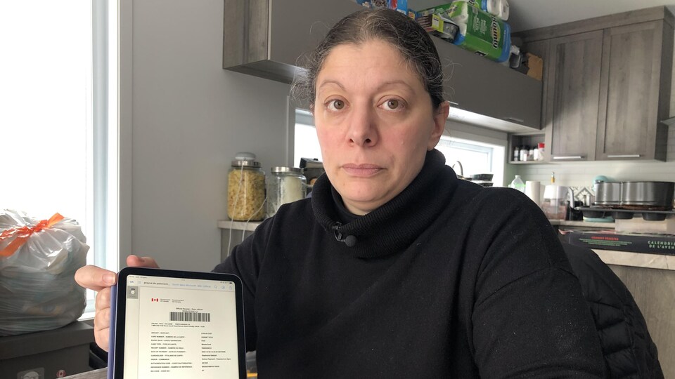 Stéphanie Debbah montre un formulaire d'Immigration Canada sur sa tablette.