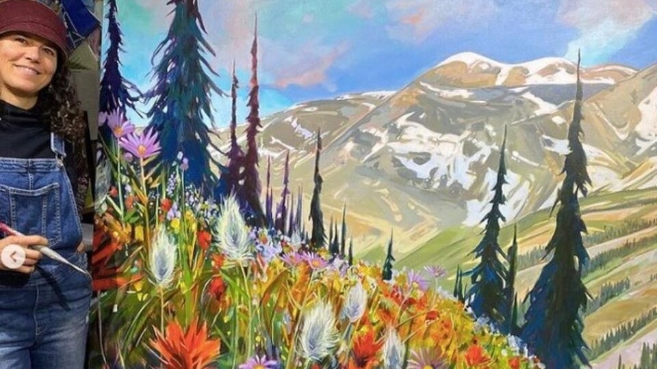 Stéphanie Gauvin pose devant une toile représentant des fleurs colorées à l'avant-plan, et des montagnes aux sommets enneigés à l'arrière-plan.