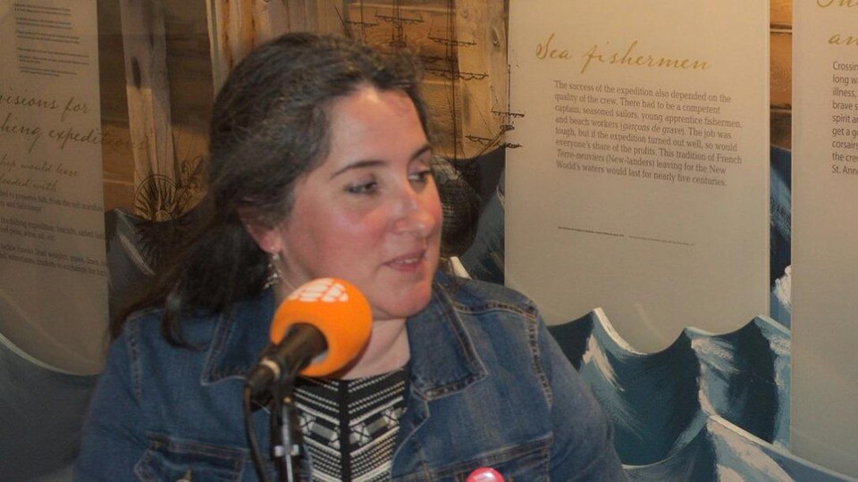 Portrait de Stéphanie Thibaud devant un micro de radio. 