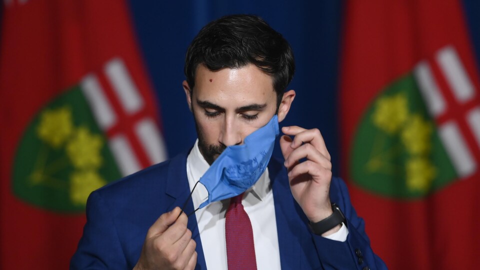 Ontario Education Minister Stephen Lecce takes his mask off before answering questions after announcing that schools will not resume-in-class learning until September during a press conference at Queen's Park in Toronto on Wednesday, June 2, 2021. THE CANADIAN PRESS/Nathan Denette