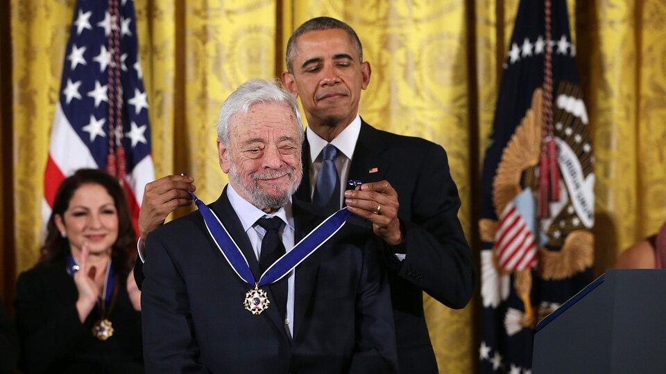 Un homme se fait accrocher une médaille au cou par le président Barack Obama. 